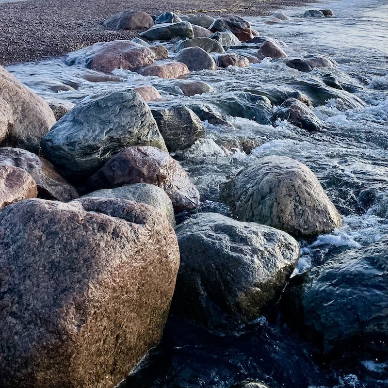 Aallot osuvat rantakiviin.