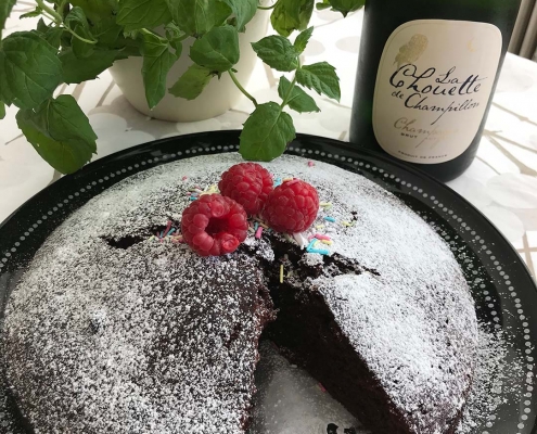 Koristeltu suklaakakku ja samppanjapullo