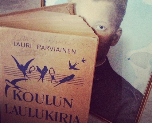 Valokuva isästä ja hänen laulukirjastaan.