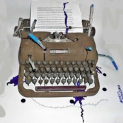 Rikkinäisestä kirjoituskoneesta valuu mustetta valkoiselle paperille.