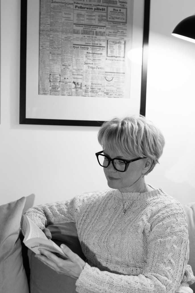 Tuija lukemassa kirjaa sohvalla.