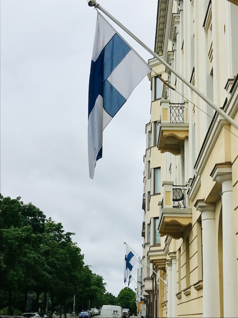 Suomen liput heiluvat kadunvarressa Merikadulla.