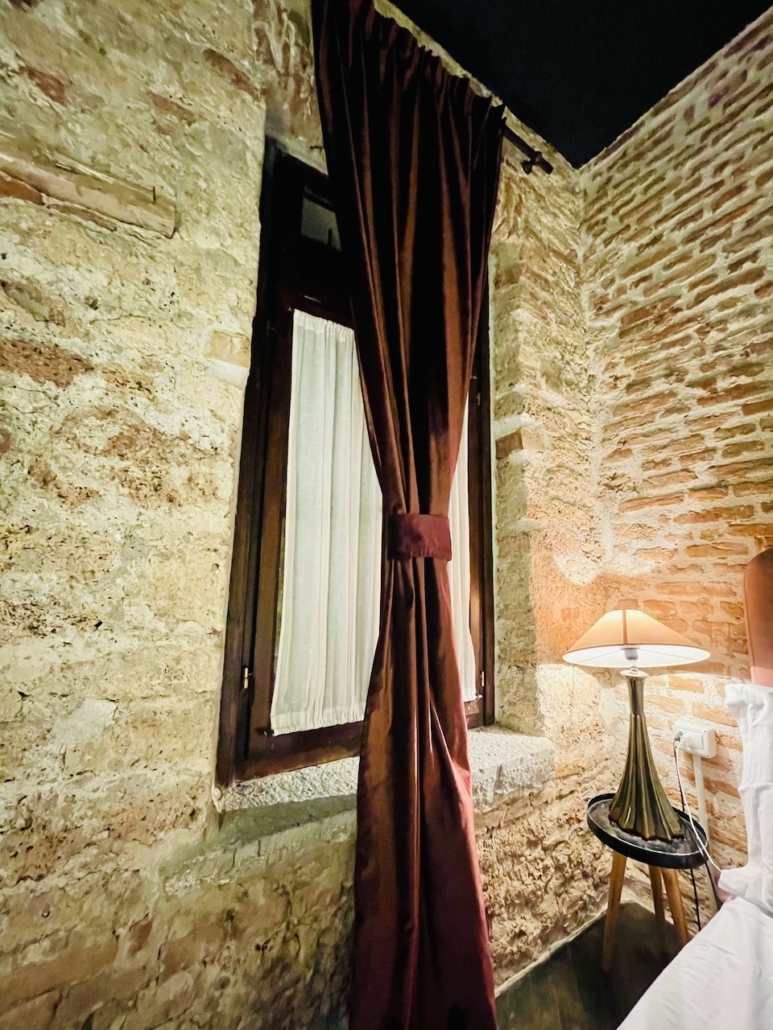 Hotellihuoneen seinät ovat rosoista kiveä.