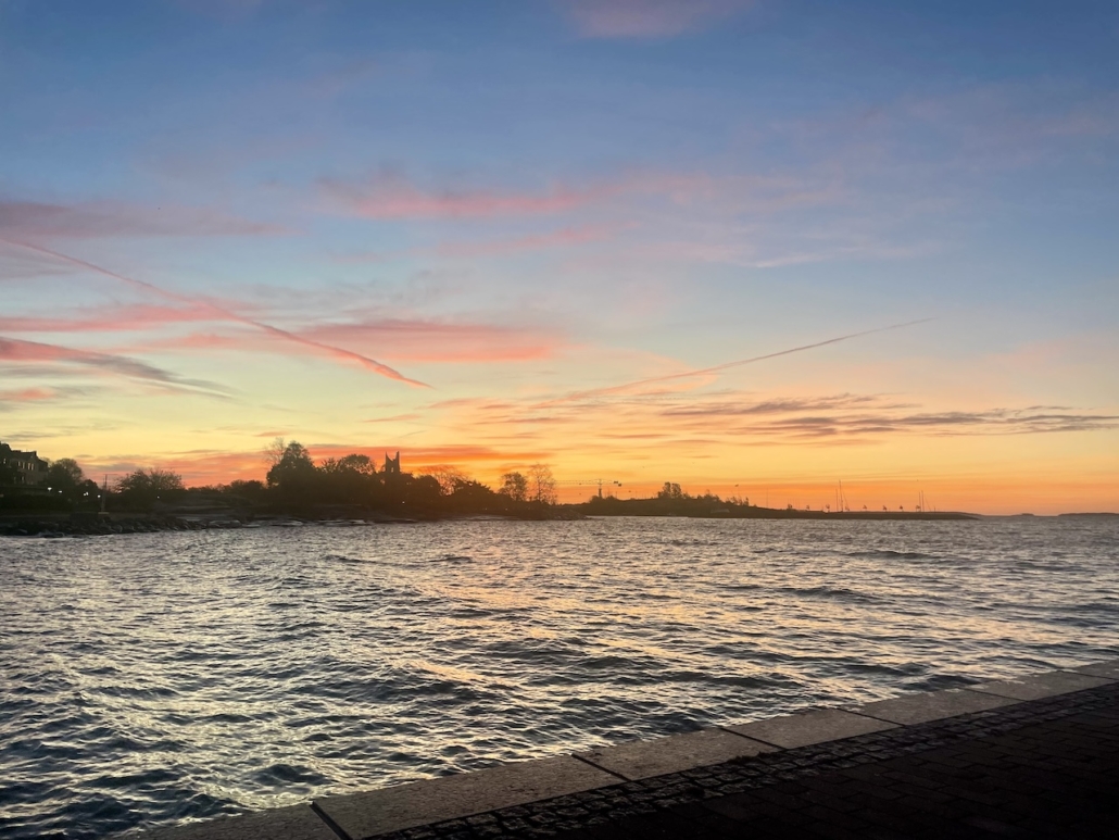 Keltaisen, punaisen ja sinisen kirjavana leimuava taivaanranta vähän ennen auringonnousua.