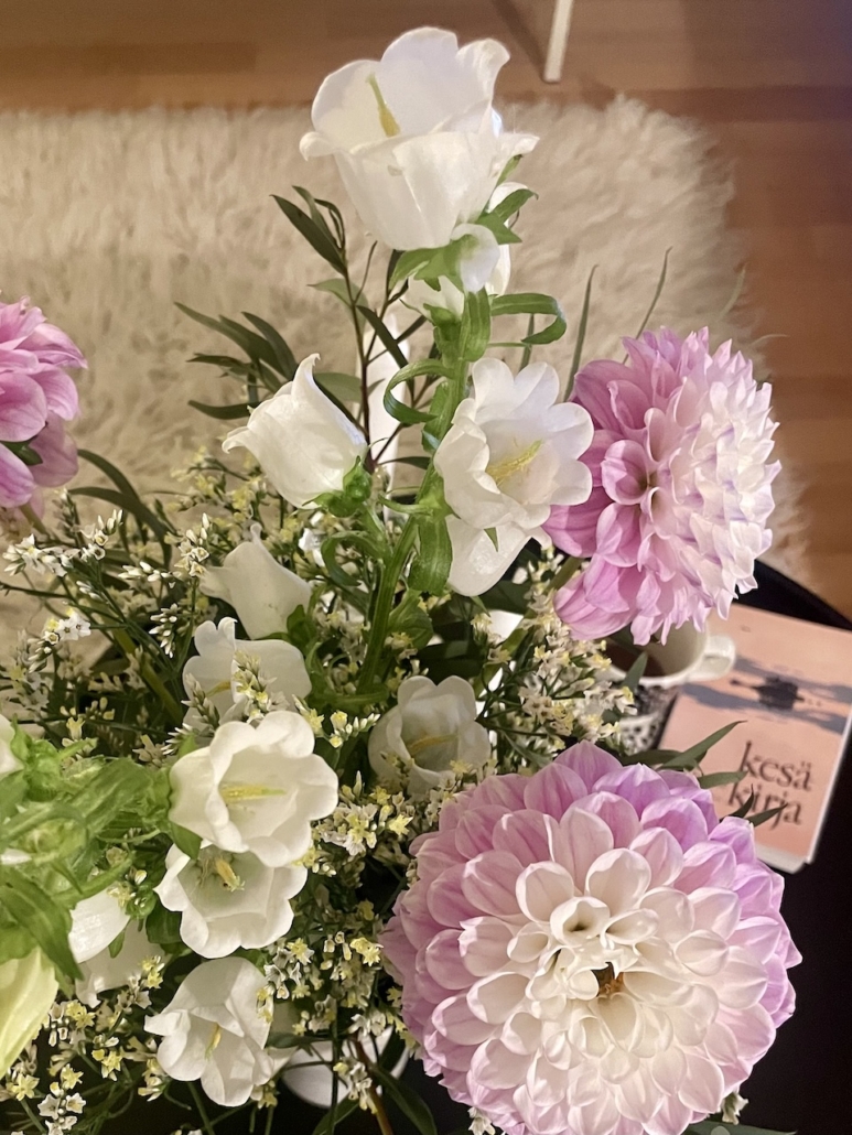 Kesäkukkia maljakossa ja Tove Janssonin kesäkirja.