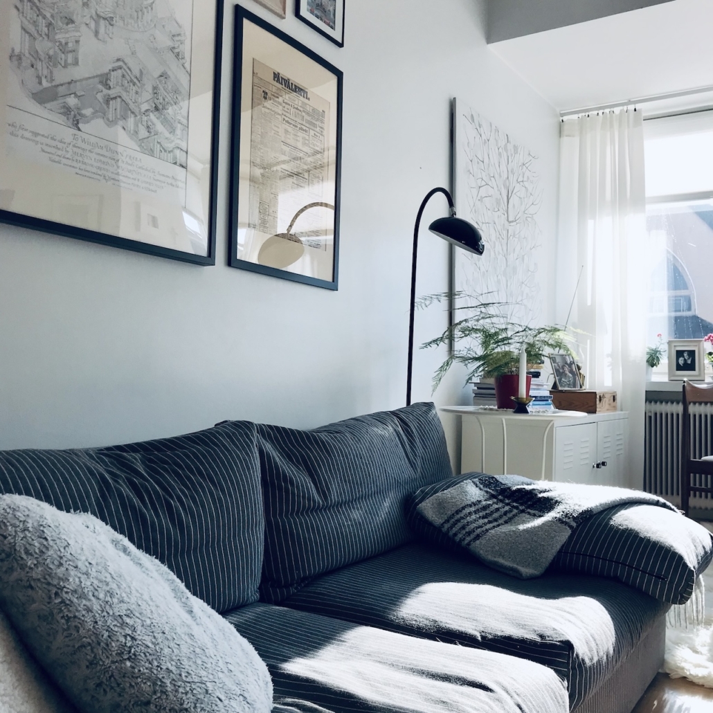 Harmaa-valkoraidalinen sohva.