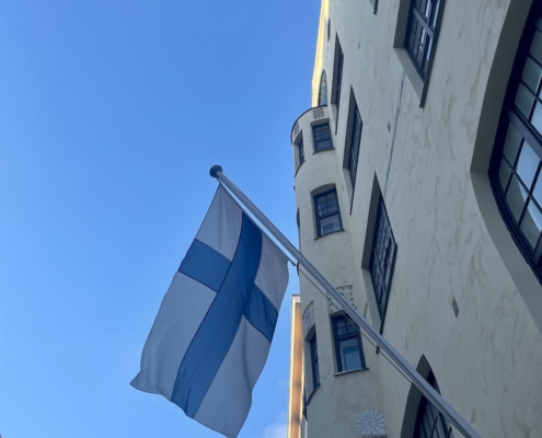 Suomen lippu liehuu kerrostalon edessä.