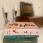 Kolme uutta kirjaa pinossa pöydällä.