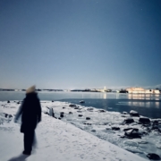 Ihmisen hahmo meren horisontissa näkyviä valoja vasten.