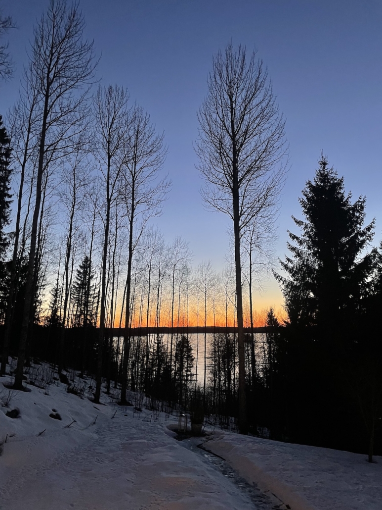 Järvimaisema ja punaisena hehkuva taivaanranta.