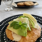 Skonsseja juuston ja avokadon kera mustalla lautasella.