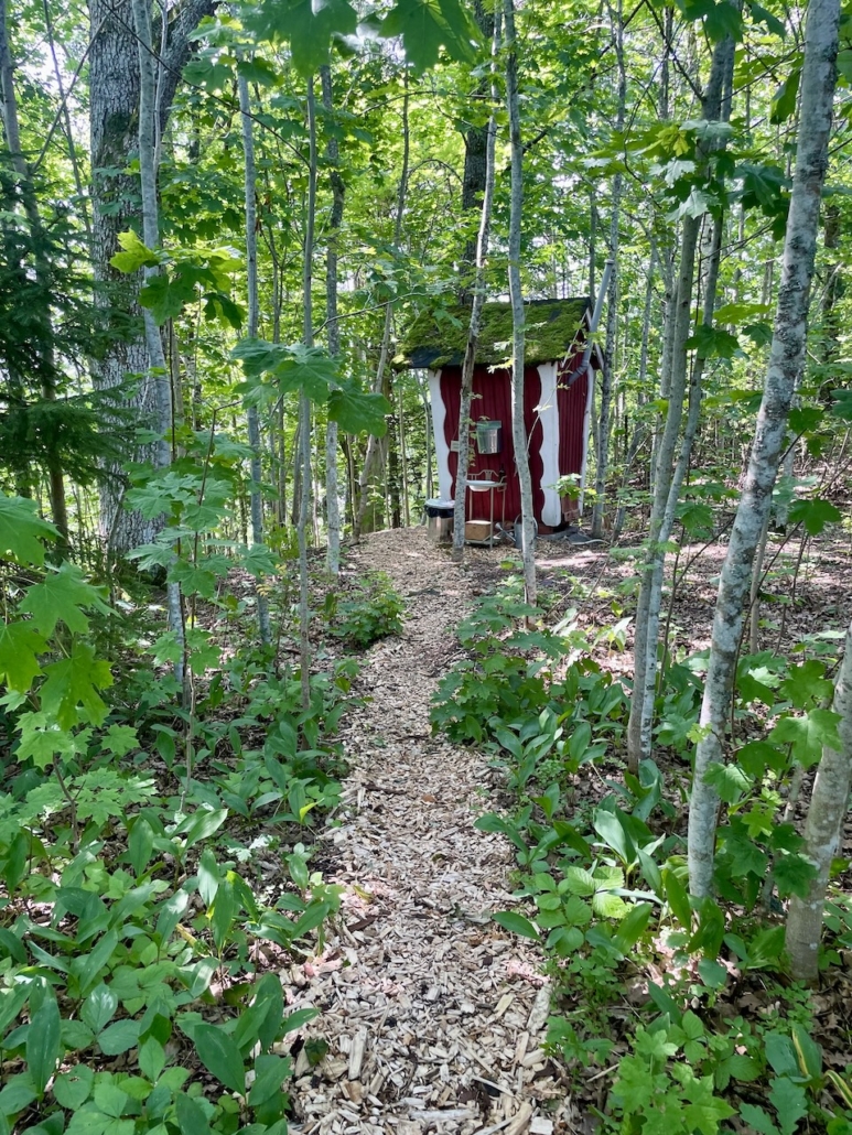 Polku johtaa punaiseen ulkohuussiin.