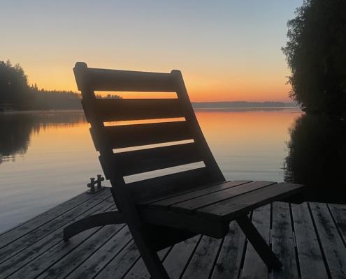 Punakeltainen järvimaisema keskiyön aikaan.