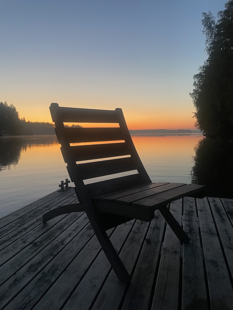 Punakeltainen järvimaisema keskiyön aikaan.
