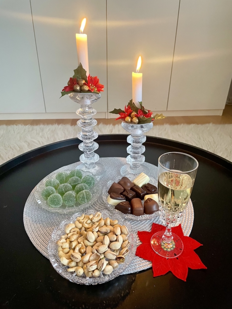 Festivo-kynttilänjalat ja jouluherkkuja pöydällä.