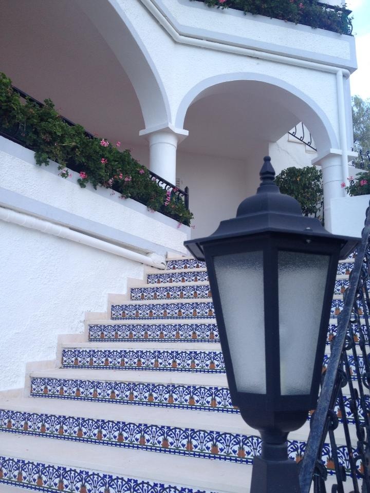 Huvilan sinivalkoiset portaat Marbellassa ja valolyhty.