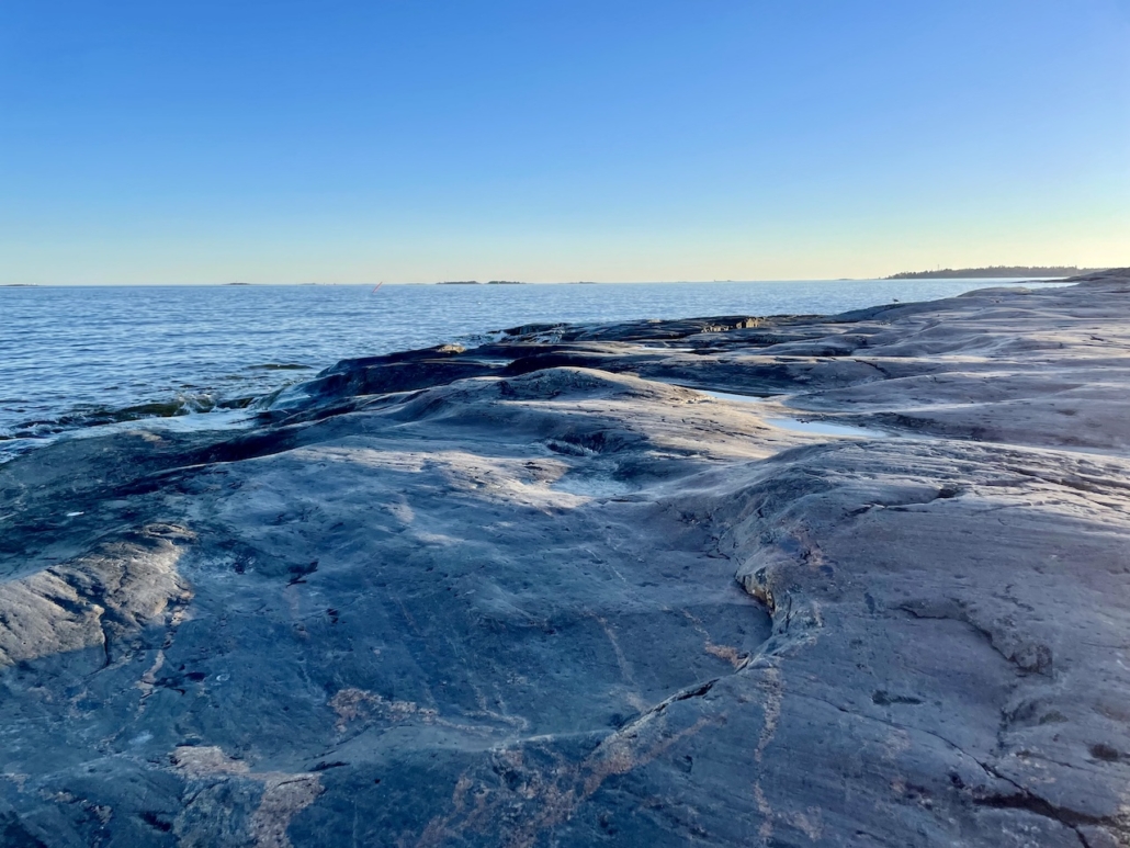 Kallioiden kirjavia muotoja ja meri.