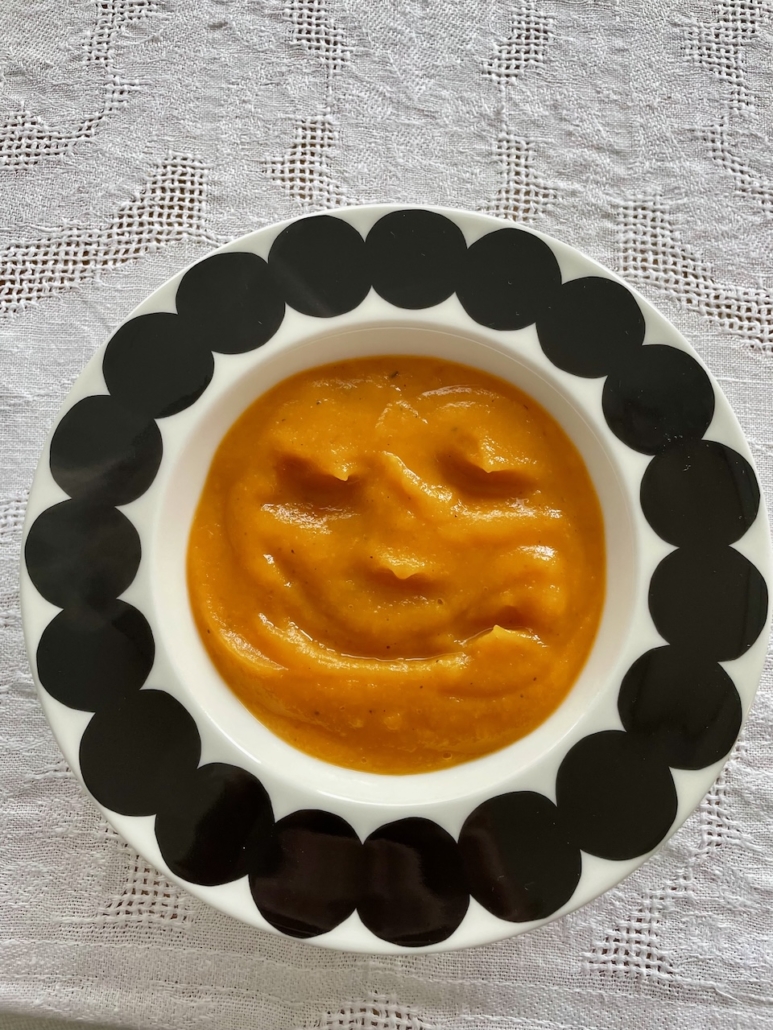Lautasella porkkanakeittoa johon on piirretty naaman kuva.