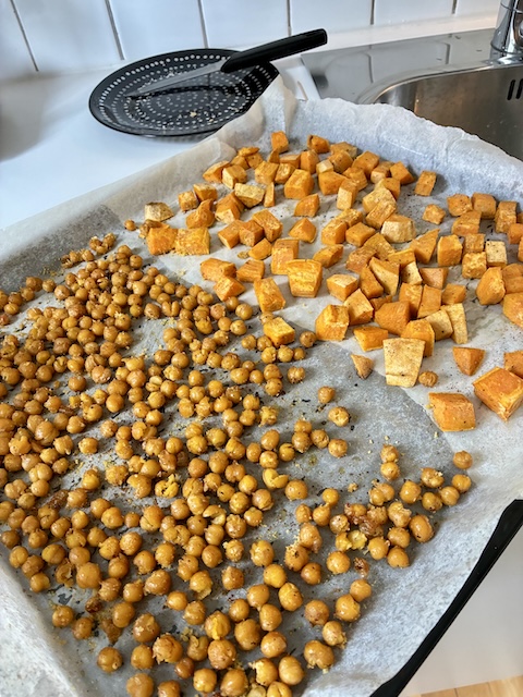 Kikherneet ja bataatit Paahdettuja kikherneitä ja bataattilohkoja uunipellillä.