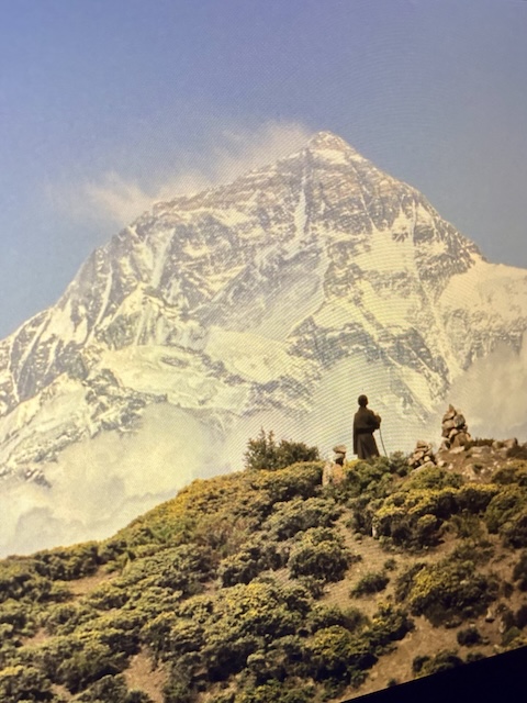 Taustalla jäinen Mount Everest ja Tenzing sitä unelmoimassa.